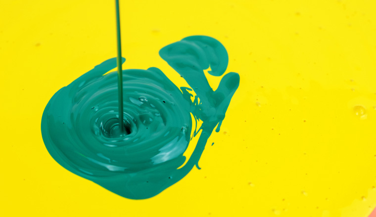 Pouring green paint in the yellow paint