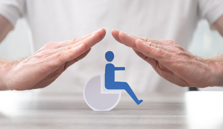Disabled person protected by hands - Concept of disability insurance