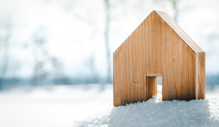 Kleines Haus aus Holz steht im Schnee, Konzept Bauen und Grundstück oder Hüttenurlaub