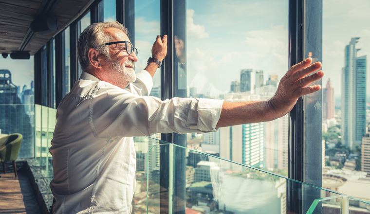 portrait of senior businessman with beard and glasses feeling confident standing in executive room in business building