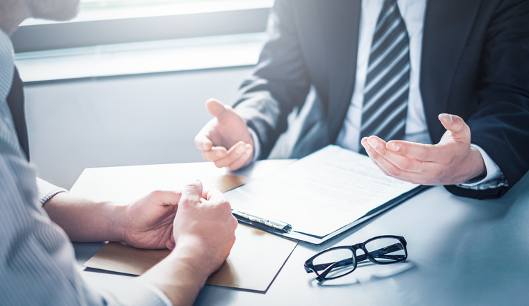 Business people negotiating a contract. Human hands working with documents at desk and signing contract.