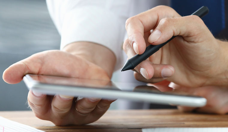 Focus on colleagues hands holding modern tablet and stylos. Businessmen discussion new biz project. Designers creating start-up. Creative work concept. Blurred background