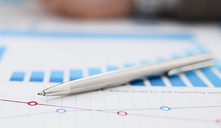 Black calculator and financial statistics on clipboard pad at office table closeup. Internal Revenue Service inspector sum check irs investigation earnings savings loan and credit concept