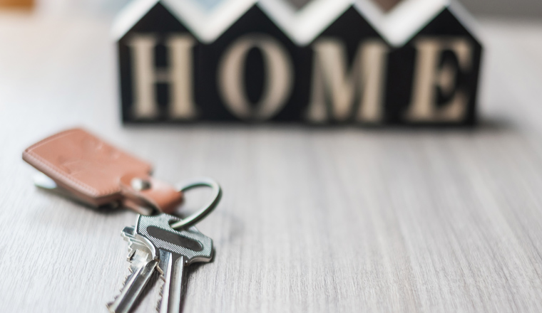 key and wooden Home model on table office. New House, Financial, Property insurance and real estate concepts