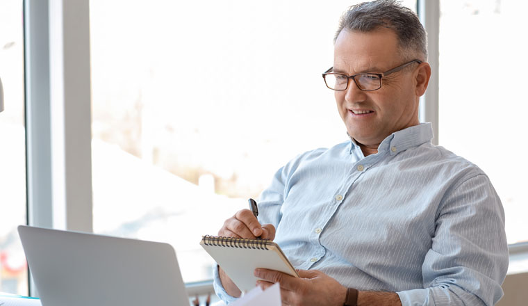 Mature man using laptop at home