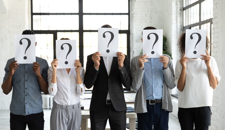 Diverse business people hiding faces behind papers sheets with question marks, standing in row in office. Identity and equality employee at work, candidates waiting for job interview, recruitment.