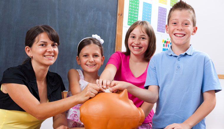 Students and teacher saving money by putting big coin into piggy bank