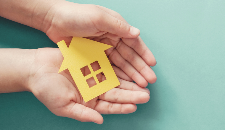 hands holding paper house, family home, homeless housing and home protecting insurance concept, international day of families, foster home care, homeschooling, social distancing 