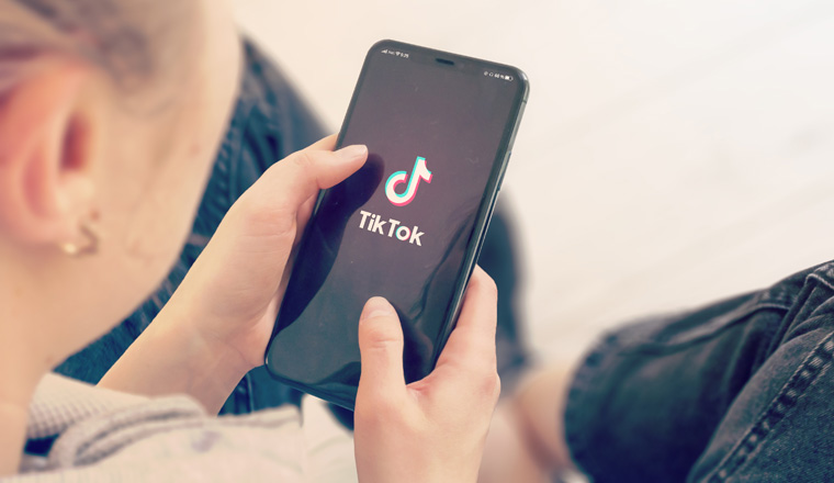 KYIV, UKRAINE-JANUARY, 2020: Tiktok on Smart Phone Screen. Young Girl Pointing or Texting Tiktok on Smart Phone During a Pandemic Self-Isolation and Coronavirus Prevention.