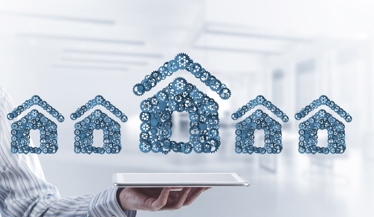 Close of businessman holding tablet pc with house sign made of connected gears. Mixed media