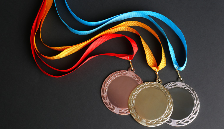 Gold, silver and bronze medals on black background, flat lay. Space for design