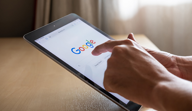 Bangkok, Thailand 25 AUG 2020. Men hand using digital tablet for search information on Google.  Wireless Smartphone technology with intelligence search engine.