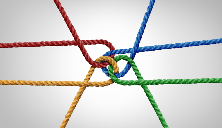 Connected team concept and unity or teamwork idea as a business metaphor for joining a partnership as diverse ropes tied together as a corporate symbol for cooperation and working collaboration.
