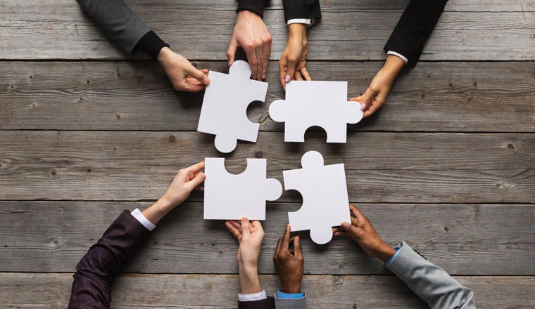 Business teamwork with white puzzle of four pieces cooperation unity concept