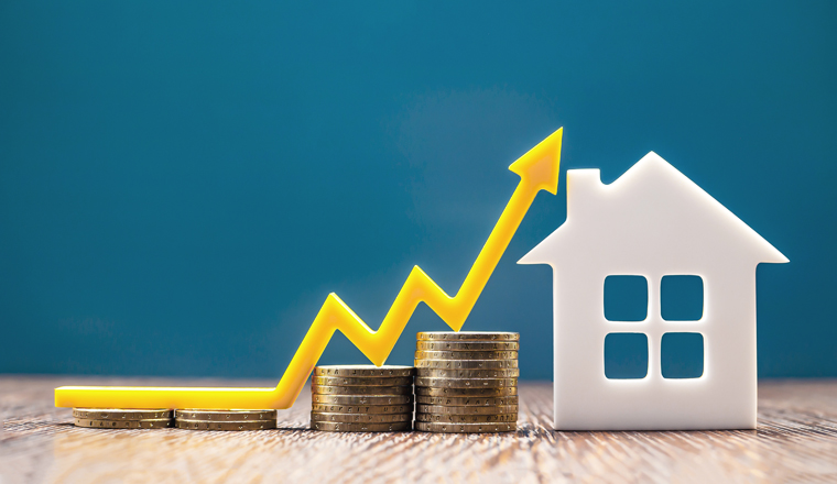 Real estate market, graph, up arrow. House model and a stack of coins. The concept of inflation, economic growth, the price of insurance services. Copy space