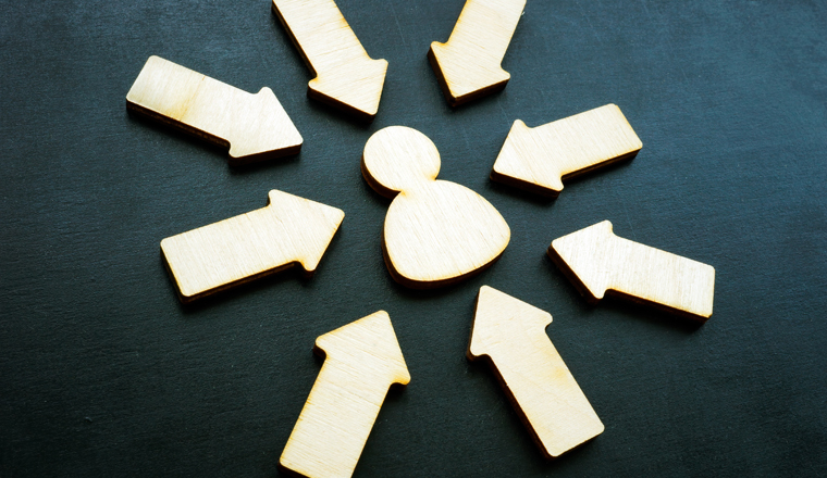 Customer centricity concept. Arrows and wooden figure on the dark desk.