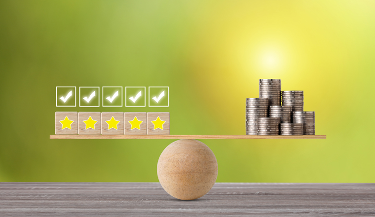 Excellent business five star rating experience on wooden block with money stacking coin on seesaw balancing, meaning business gain money after customer satisfaction