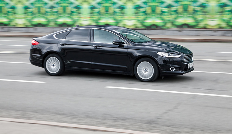 Moscow, Russia - April 2021: Ford Mondeo MK5 goes fast on the asphalt road. Fourth-generation Ford Mondeo in city street