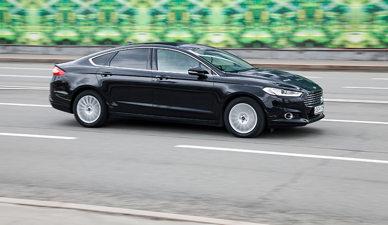 Moscow, Russia - April 2021: Ford Mondeo MK5 goes fast on the asphalt road. Fourth-generation Ford Mondeo in city street