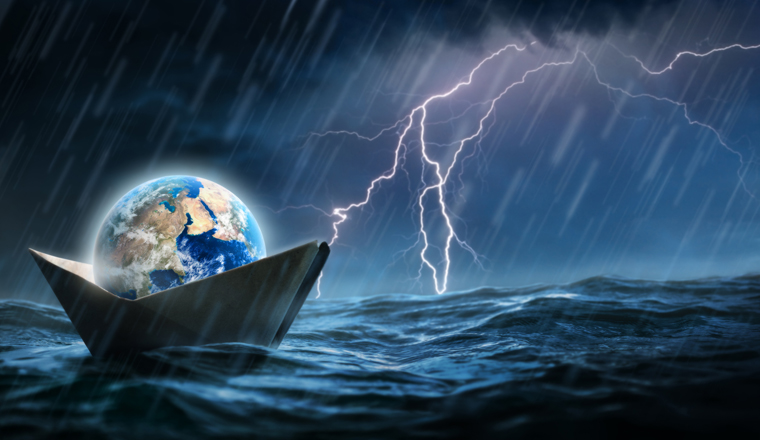 World in a paper boat floating in the ocean in a middle of a storm. Faith despite world crisis and hardship conceptual theme.