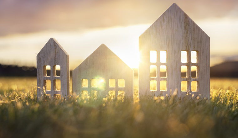 Green ecological house in empty field at sunset concept for construction and real estate