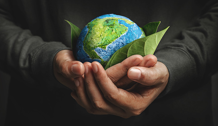 World Earth Day Concept. Green Energy, Renewable and Sustainable Resources. Environmental and Ecology Care. Hand Embracing Green Leaf and Handmade Globe