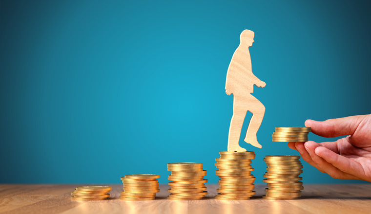 Return on investment, growing savings or wage income concept. Coins and wooden person going on increasing columns of coins. Helping hand adds more money. Successful investment concept.