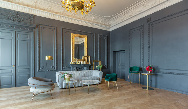 chic interior of the room in the Renaissance style of the 19th century with modern luxury furniture. walls of noble dark color are decorated with stucco and gilded frames, wooden parquet.