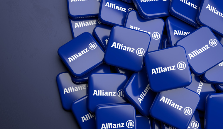 Logos of the German insurance and financial services group Allianz on a heap on a table. Copy space. Web banner format.
