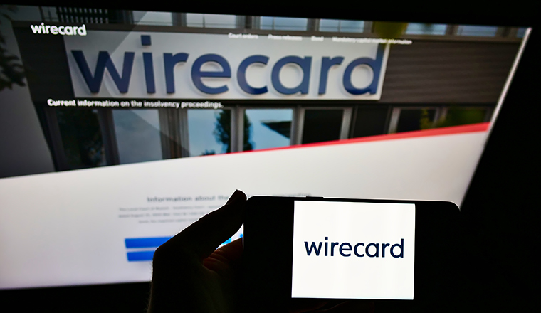 STUTTGART, GERMANY - Sep 13, 2021: Person holding mobile phone with logo of German payment and financial services company Wirecard AG in front of web page. Focus on cellphone display.