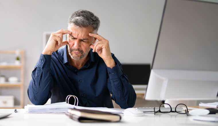 Stressed Accountant Man With Headache In Office