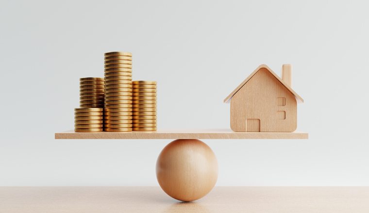 Wooden house and golden coin on balancing scale on white background. Real estate business mortgage investment and financial loan concept. Money-saving and cashflow theme. 3D illustration rendering