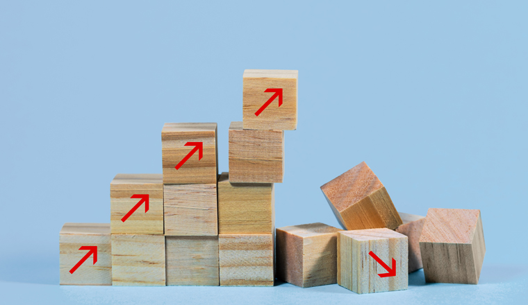 Collapsed stair structure of wooden cubes with upward pointing arrows, business risk due to inflation, global crisis, supply shortage or unsustainable financial concept, light blue background with copy space, selected focus