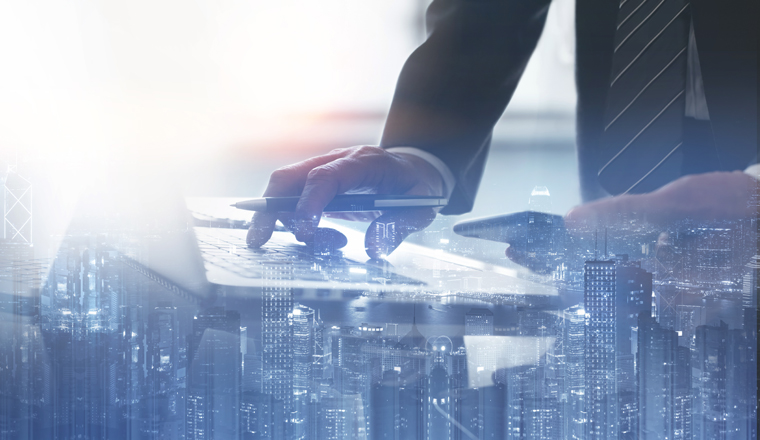 Business finance and investment concept. Double exposure of businessman working on laptop computer and the city, office buildings for business and financial technology background, panorama web banner