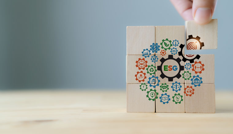ESG concept of environmental, social and governance. Sustainable corporation development. Hand holds wooden cubes with ESG target icon  standing with other ESG icons on grey background. Copy space.