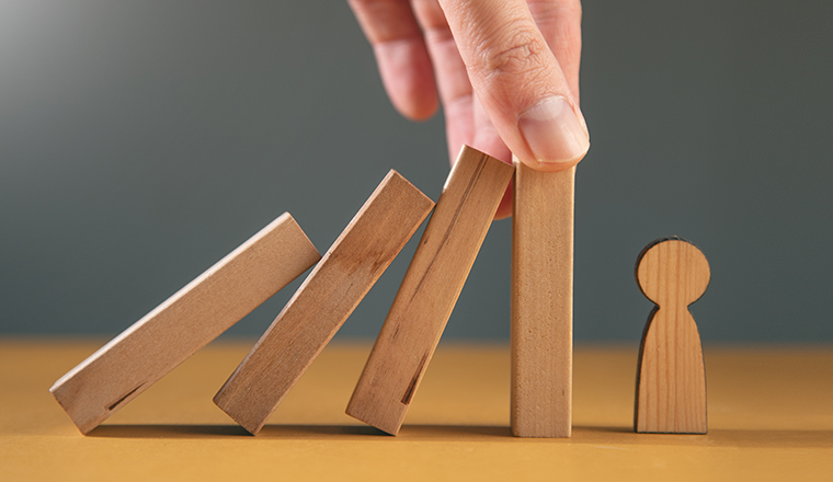 Man holding insurance with wooden people.