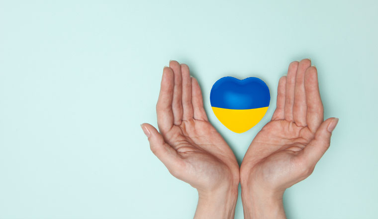 Heart with print the national flag of ukraine in female hands. Flat lay. Copy space.