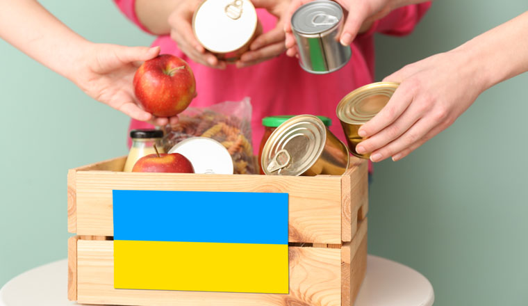 People putting donations in box on table. Humanitarian aid for Ukraine