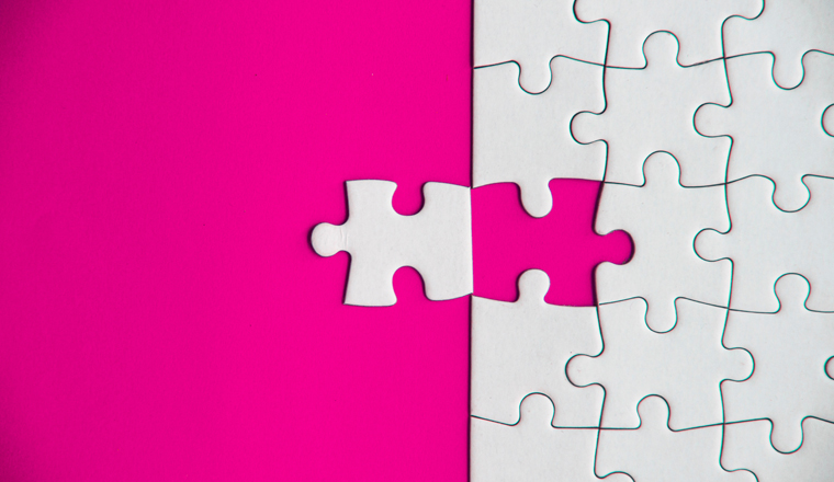 Top view of missing jigsaw puzzle on pink cover background. Copy space concept