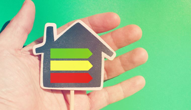 Hand holding a house with the energetic classification arrows.