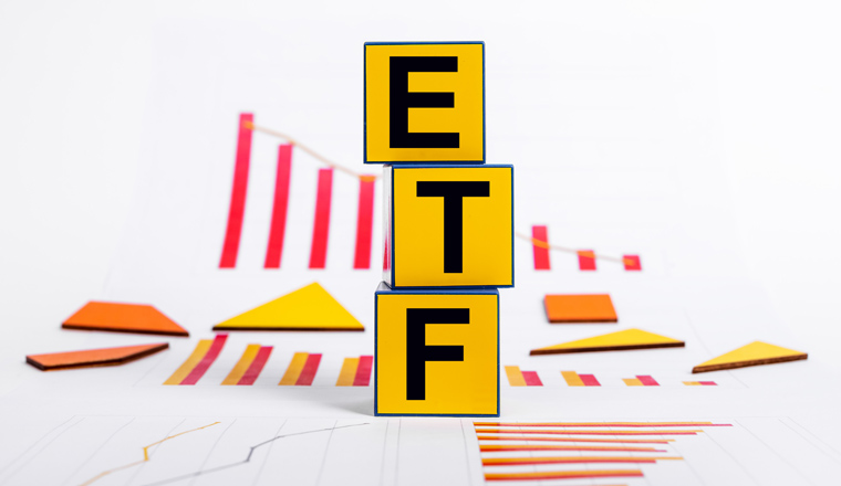 Exchange traded funds falling. Cubes with ETF abbreviation and graphs showing stock market fall. Economic recession and crisis. Investment and finance concept. High quality photo