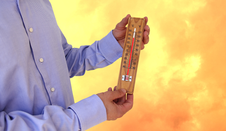 male hands hold thermometer, blurred background, orange sky with dark clouds, heat wave concept, global warming problem, natural disasters, physical well-being of people, meteorological dependence