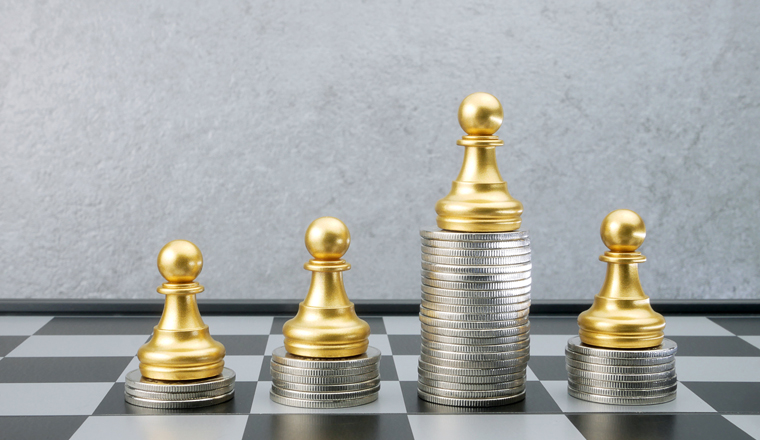 Chess with piles of coins on the board. Plan the use of money. Selective focus.