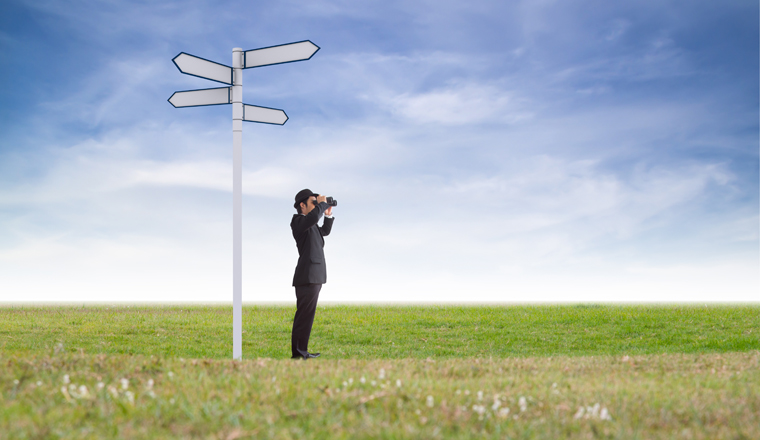 Businessman using binoculars looking direction.