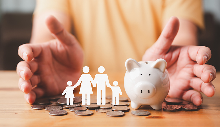 Businessman take a position to protect on the piggybank and paper family in hand, donation, saving, charity, family finance plan concept, fundraising, superannuation, financial crisis concept