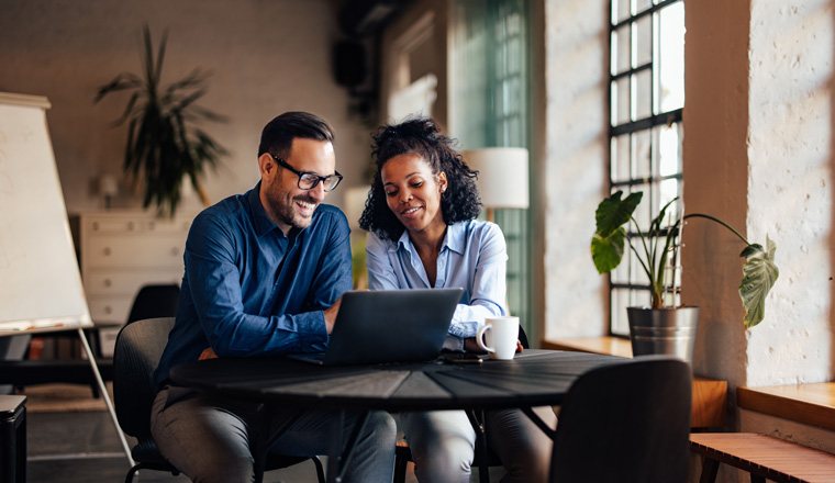 Smiling businessman and businesswoman having an online meeting.