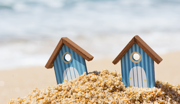 Miniature beach huts with the water line