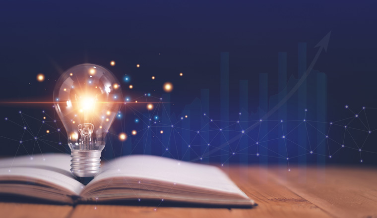 Light bulb on open book with growing graphs of stock market, Educational knowledge and business education concepts, Reading for inspiration and new idea to business grow in the future.