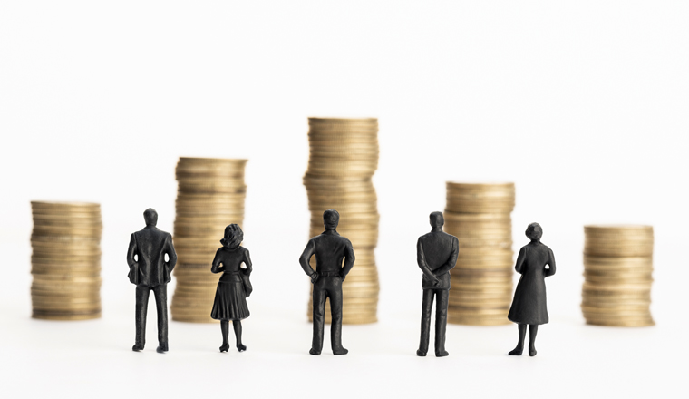 Group of figurines looking at stacks of coins. White background. Copy space. Business or economy concept