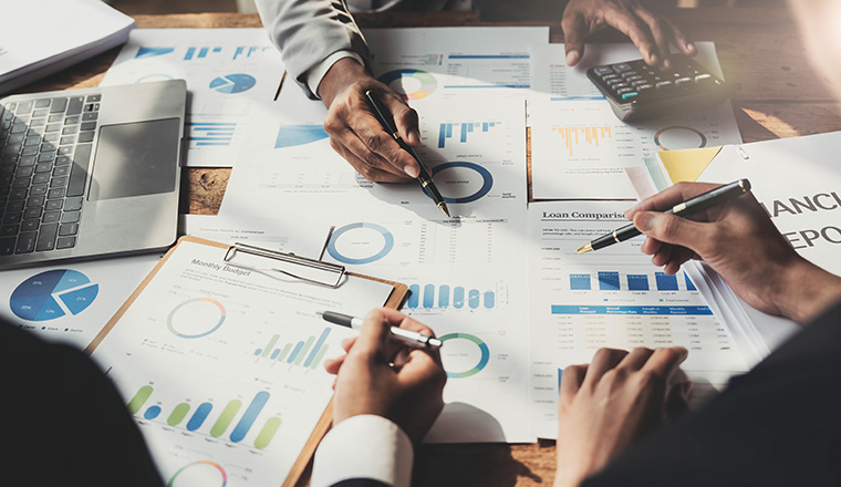 Business People Meeting using laptop computer,calculator,notebook,stock market chart paper for analysis Plans to improve quality next month. Conference Discussion Corporate Concept...